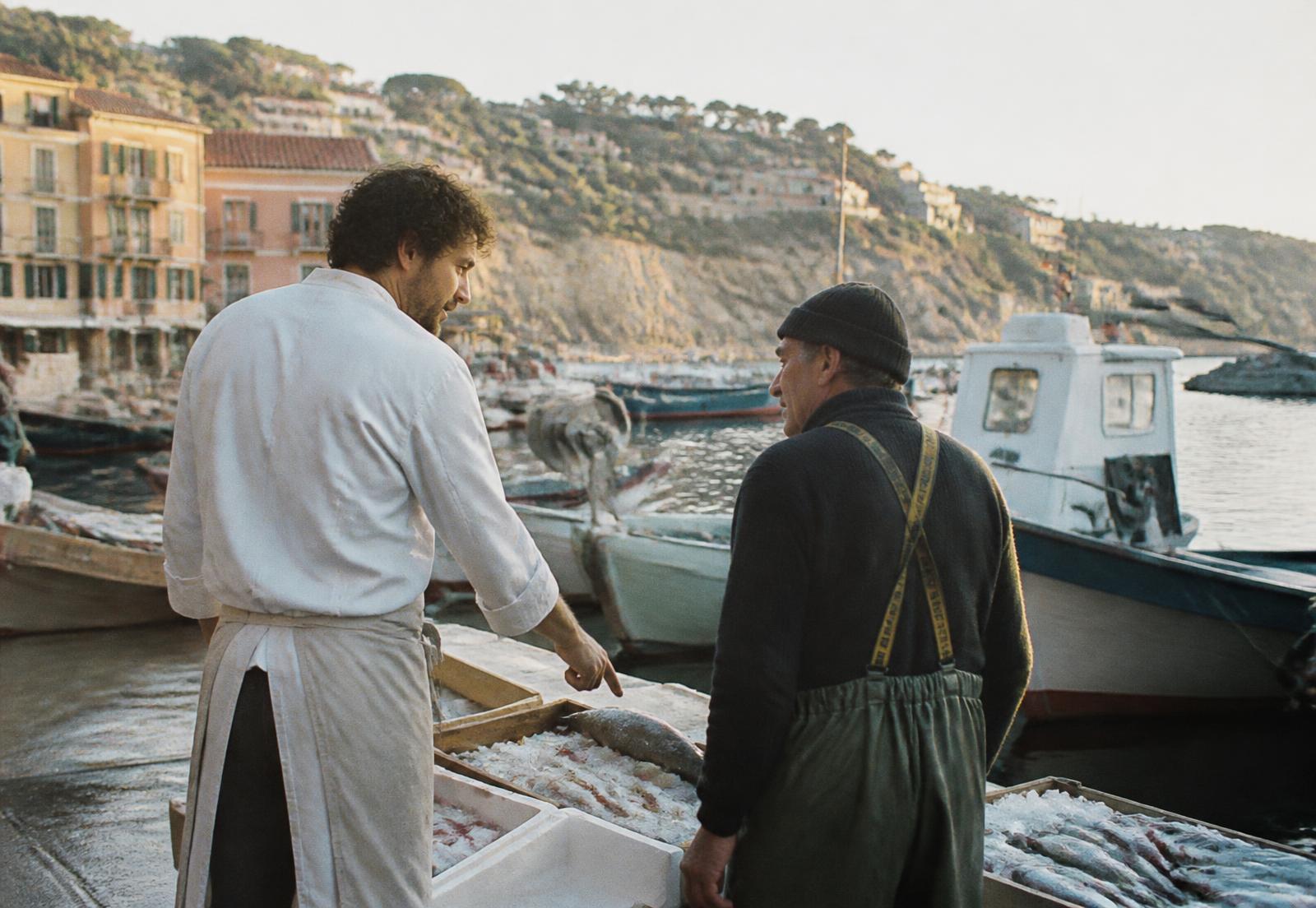 Chef Moreau at the harbour with a fisherman and crates of ice