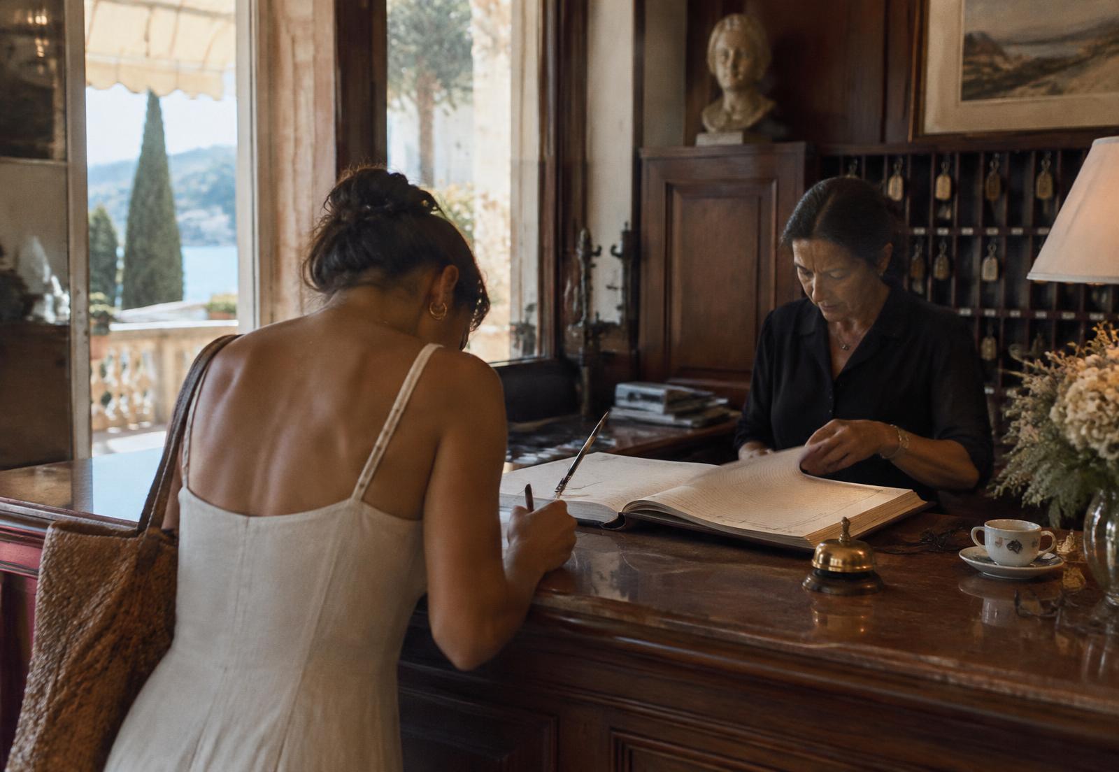 A guest signing the Carmella register while the receptionist turns the page