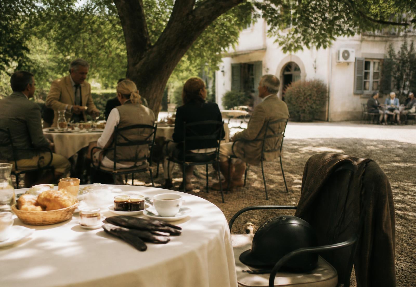 Riders back at Le Jardin for breakfast, a helmet on an empty chair